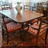 F21. Mahogany double pedestal dining table with 13 ladderback chairs, 5 leaves and pads. 1 chair is broken. 